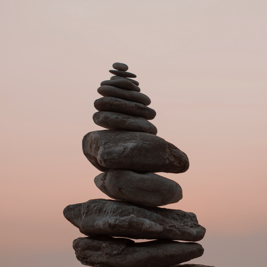 Balanced stack of smooth stones beside still water